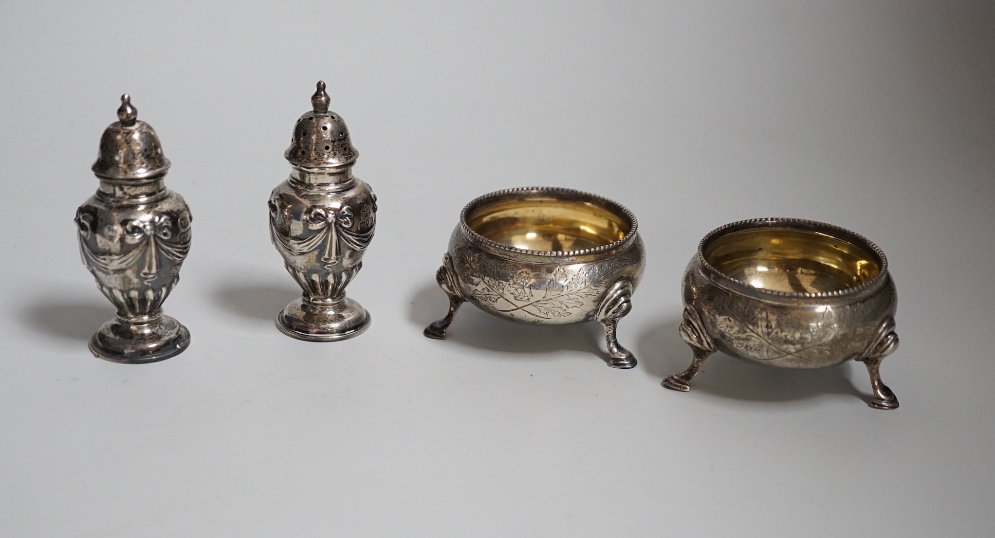 A pair of Victorian silver bun salts, London, 1868, diameter 5cm and a pair of Victorian silver peppers.